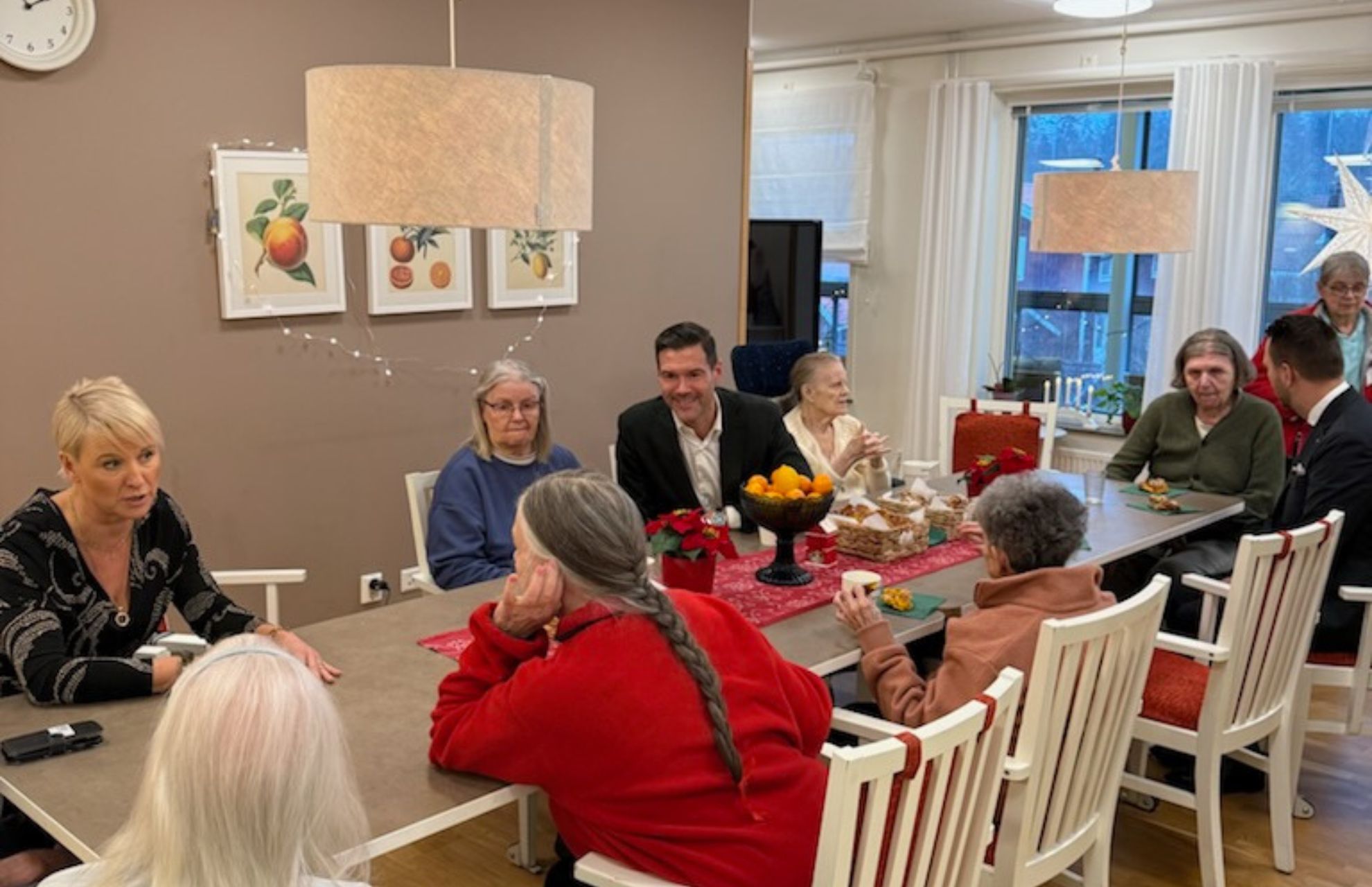 Ministrarna och de boende i samtal kring fikabordet.