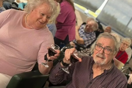 Två vänner på äldreboende skålar med varandra