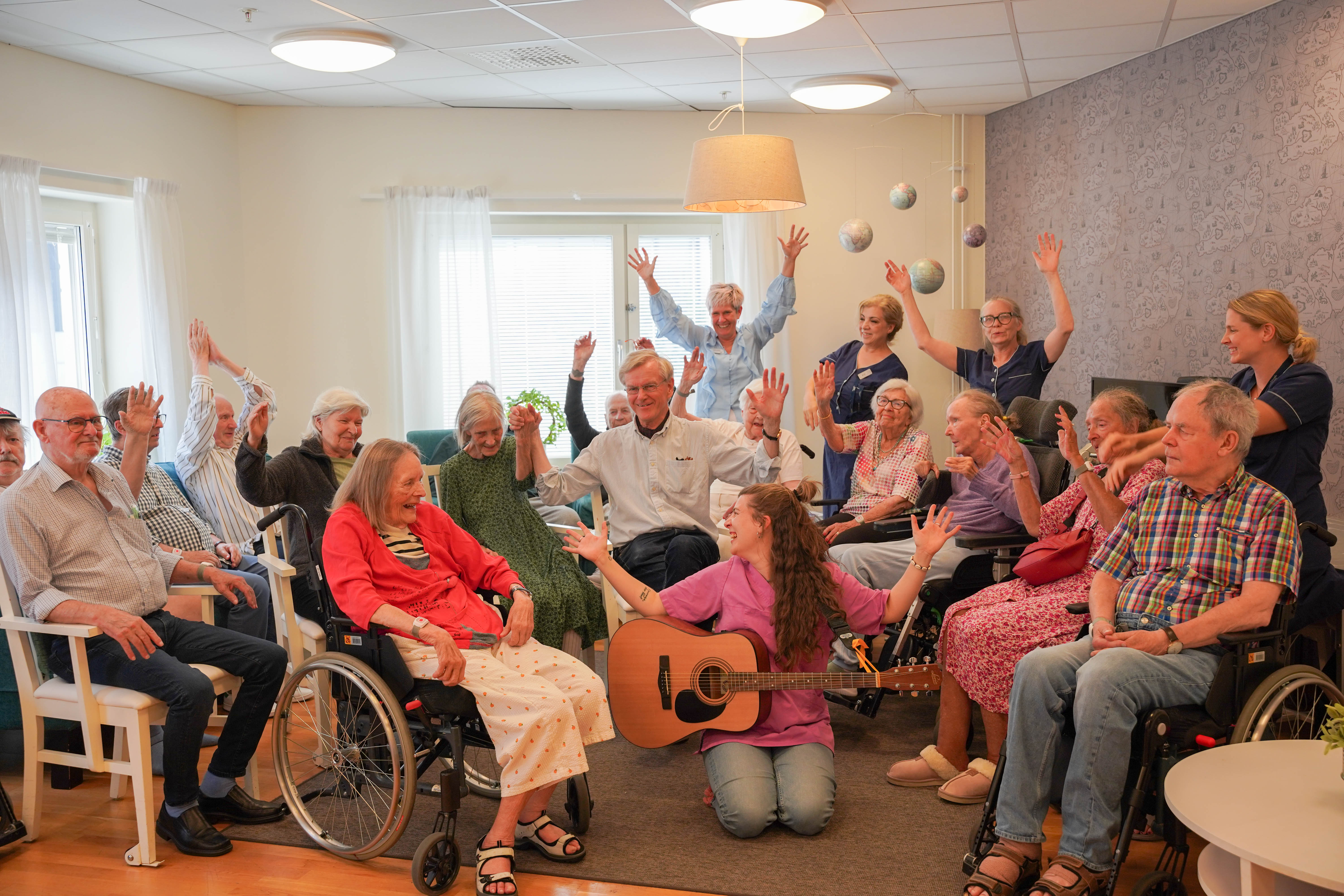 Deltagare i Hjulkören skrattar och höjer händerna