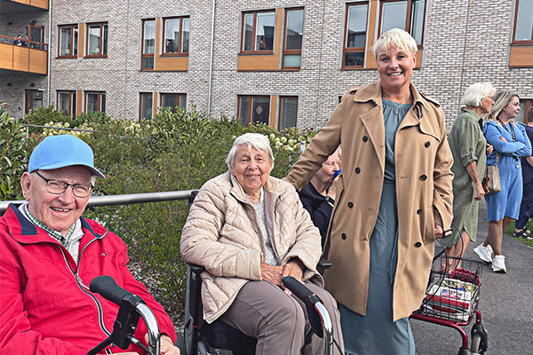 Äldreminister Anna Tenje pratar med boende i trädgården på Attendo Fridhemsvägen